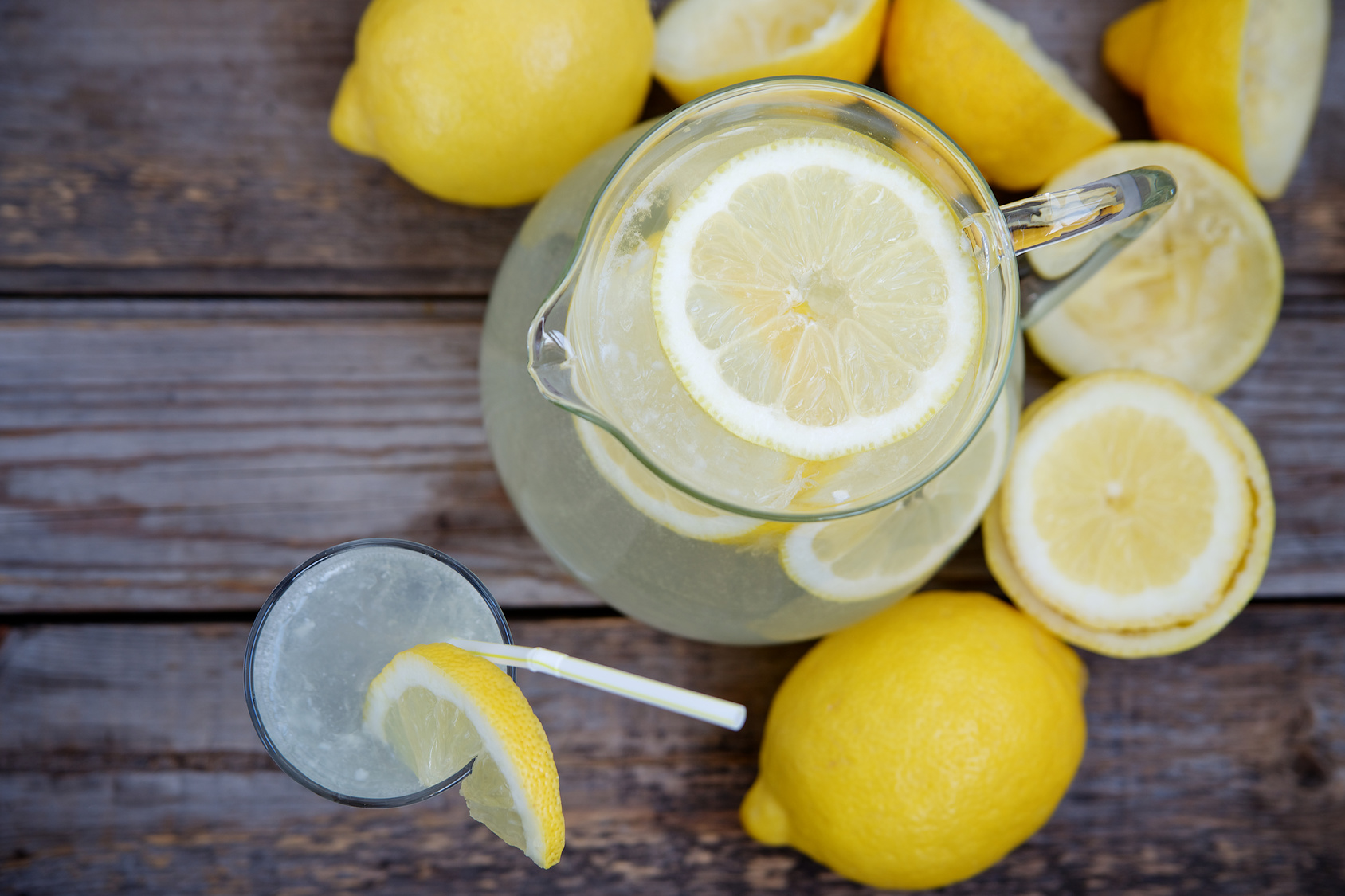Pitcher of lemonade on a wooden background