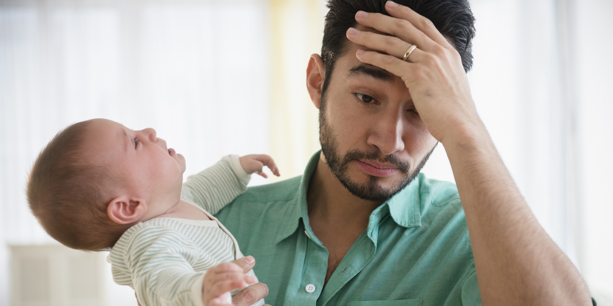 Frustrated father holding crying baby