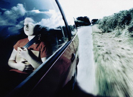 ca. 1990s --- Girl Sleeping with Book in Moving Car --- Image by © Martyn Goddard/CORBIS