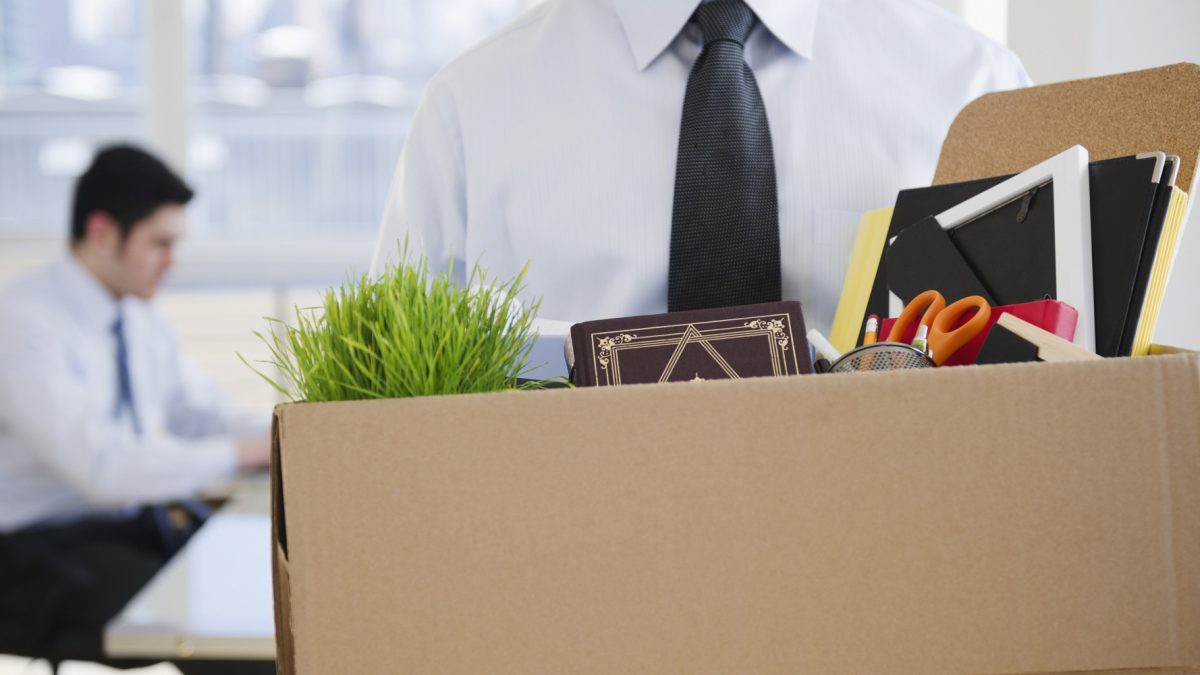 Fired Caucasian businessman carrying personal belongings