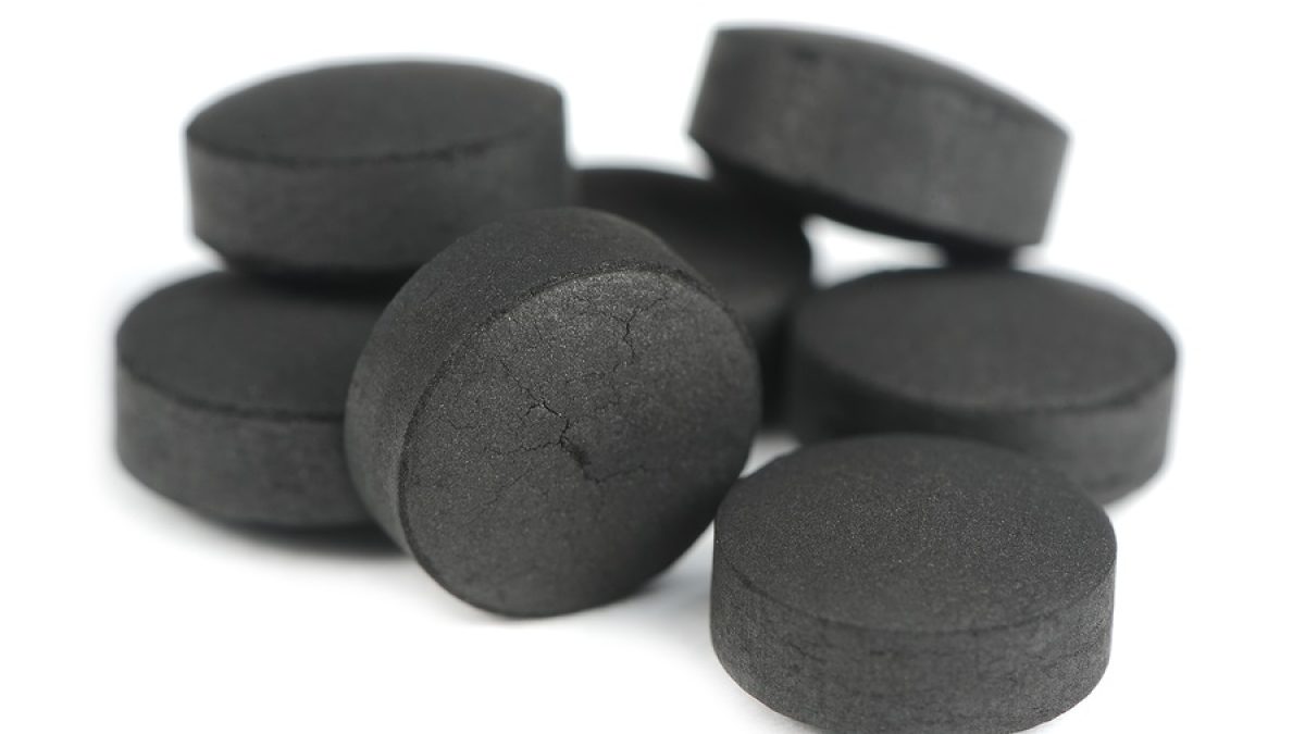 Black activated carbon (activated charcoal) pills isolated on a white background
