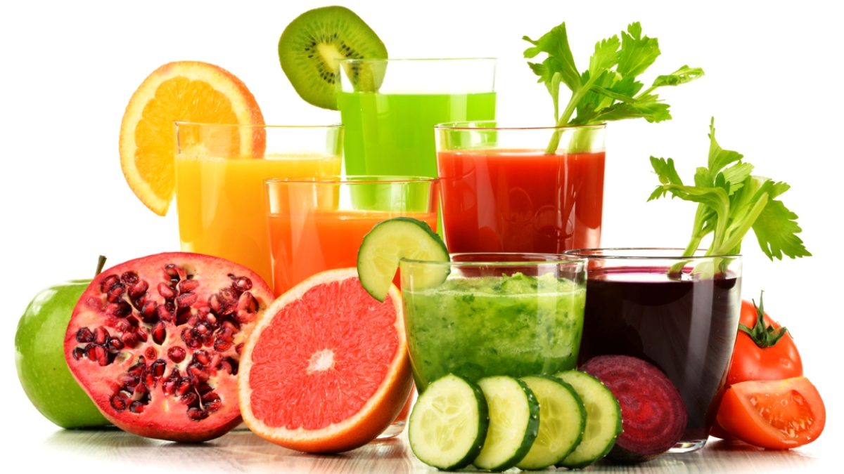 Glasses with fresh organic vegetable and fruit juices on white