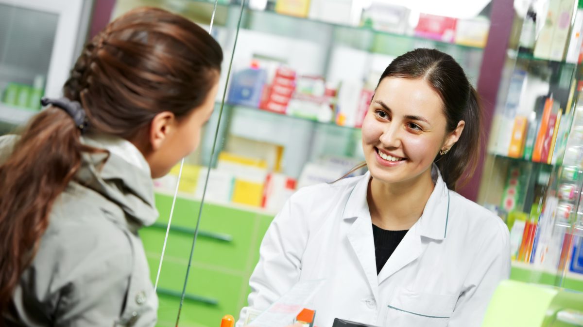 pharmacist suggesting medical drug to buyer in pharmacy drugstore