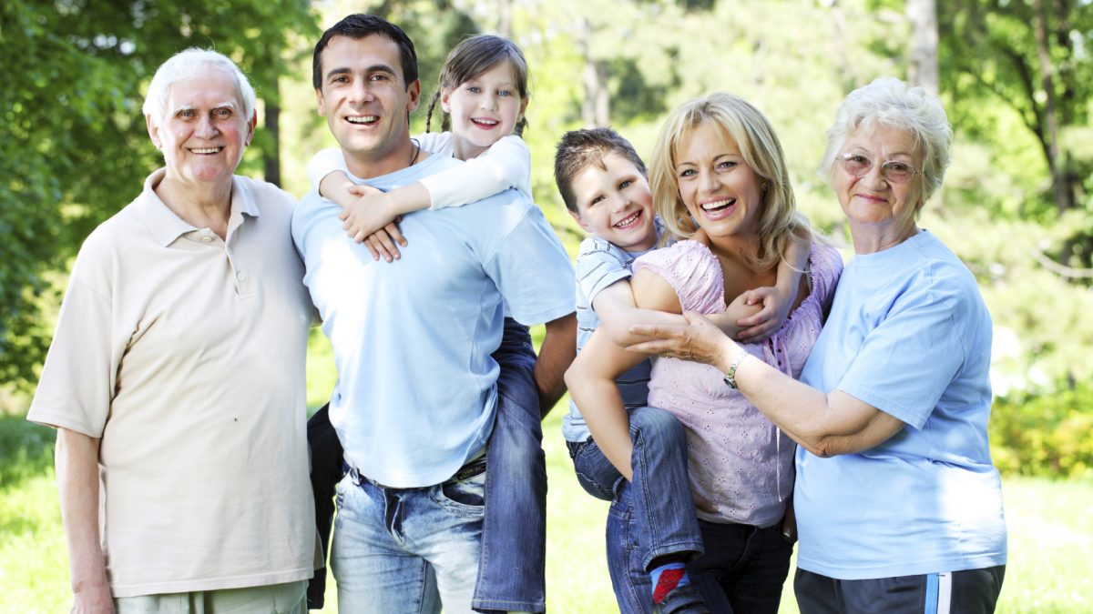 Portrait of a extended happy family standing in the park.