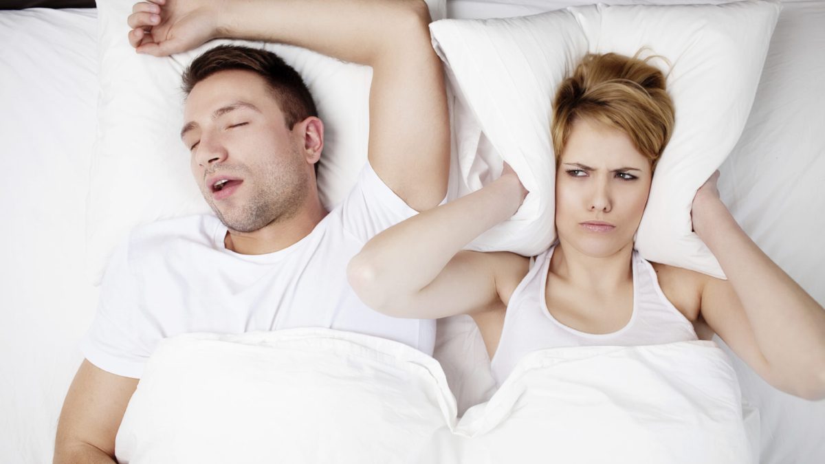 Snoring man and young woman. Couple sleeping in bed.